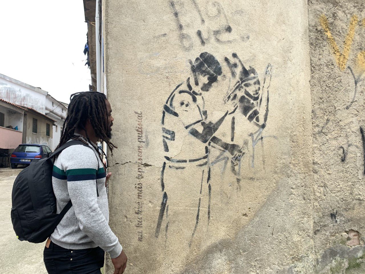 The tour guide looks at a mural depicting the police brutality residents of Cova da Moura face.